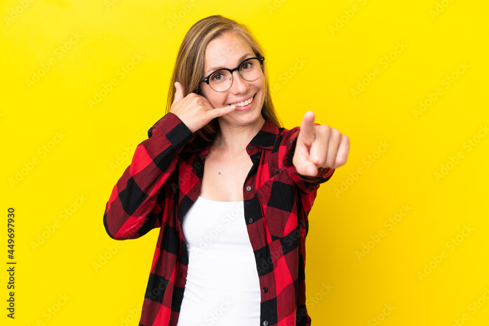 Young English woman isolated on yellow background making phone gesture and pointing front Young English woman isolated on yellow background making phone gesture and pointing front