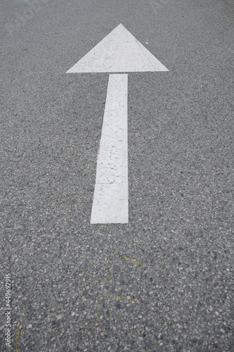 white arrow on gray asphalt on the road with copy space