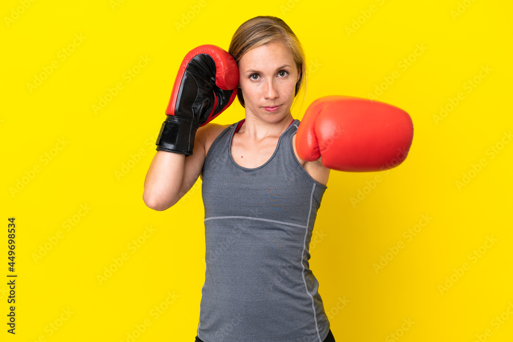 Young English woman isolated on yellow background with boxing gloves Young English woman isolated on yellow background with boxing gloves