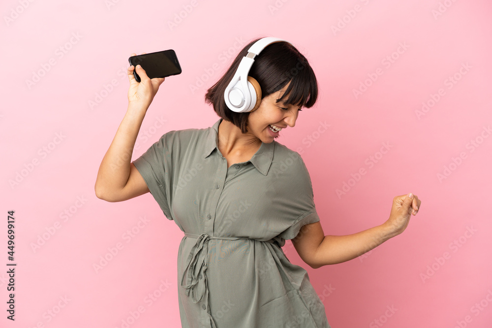 Woman over isolated background pregnant and dancing while listening music Woman over isolated background pregnant and dancing while listening music