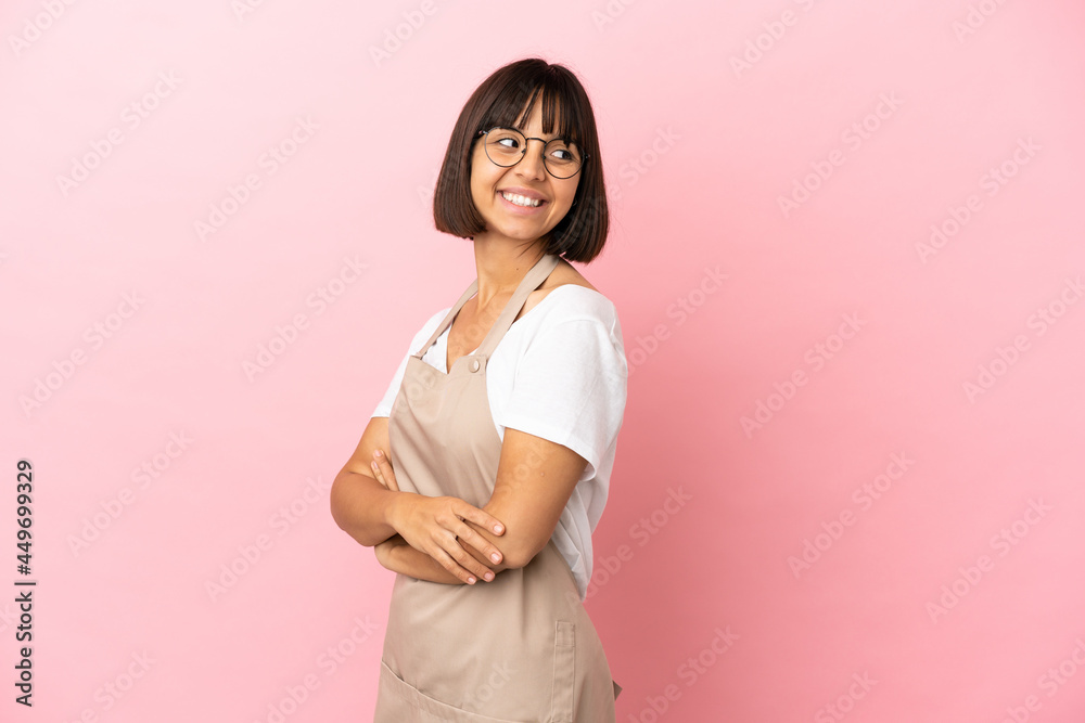 Restaurant waiter over isolated pink background looking to the side and smiling Restaurant waiter over isolated pink background looking to the side and smiling