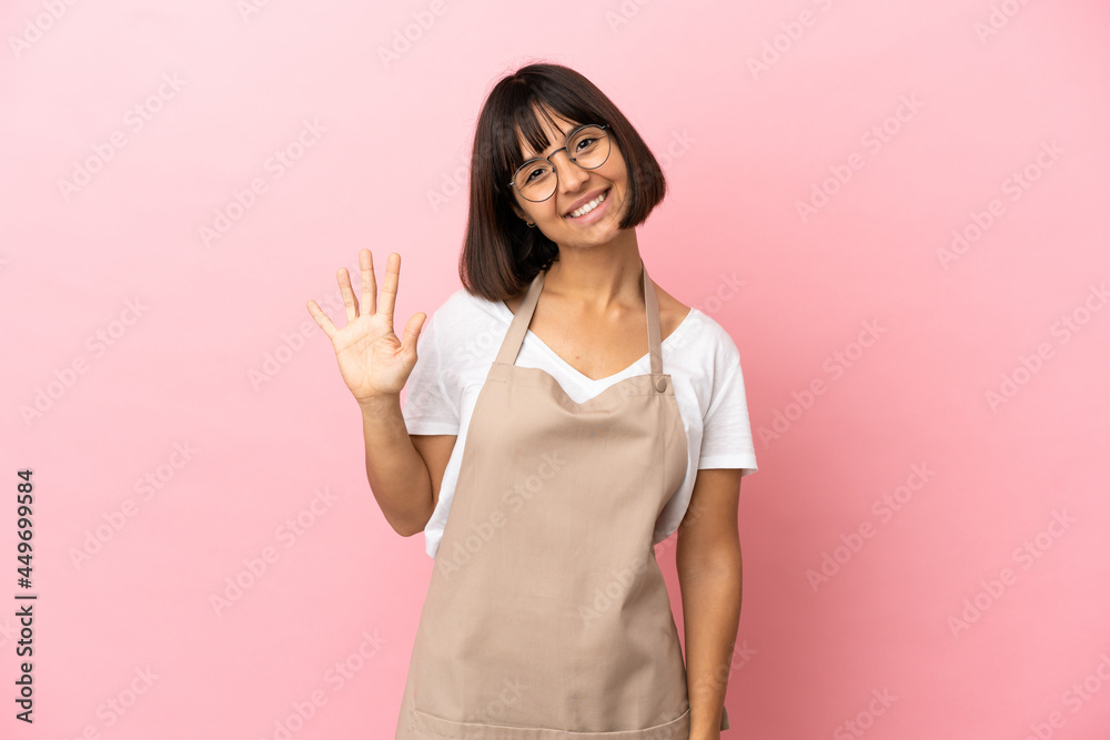 Restaurant waiter over isolated pink background counting five with fingers Restaurant waiter over isolated pink background counting five with fingers