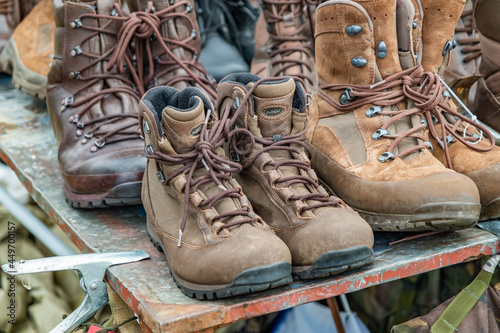 A selection of part worn and used army boots on a table display for sale at an army surplus stall