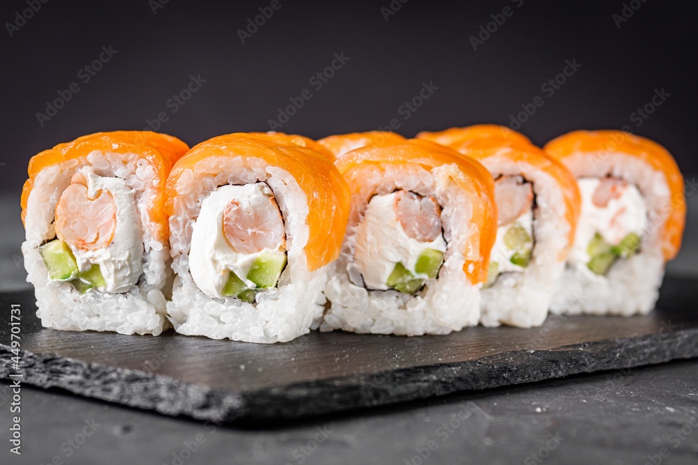 appetizing sushi roll philadelphia with shrimp cheese cucumber and salmon on a black stone plate appetizing sushi roll philadelphia with shrimp cheese cucumber and salmon on a black stone plate