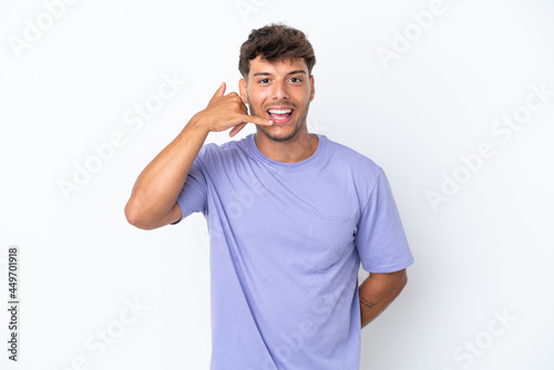 Young caucasian handsome man isolated on white background making phone gesture. Call me back sign