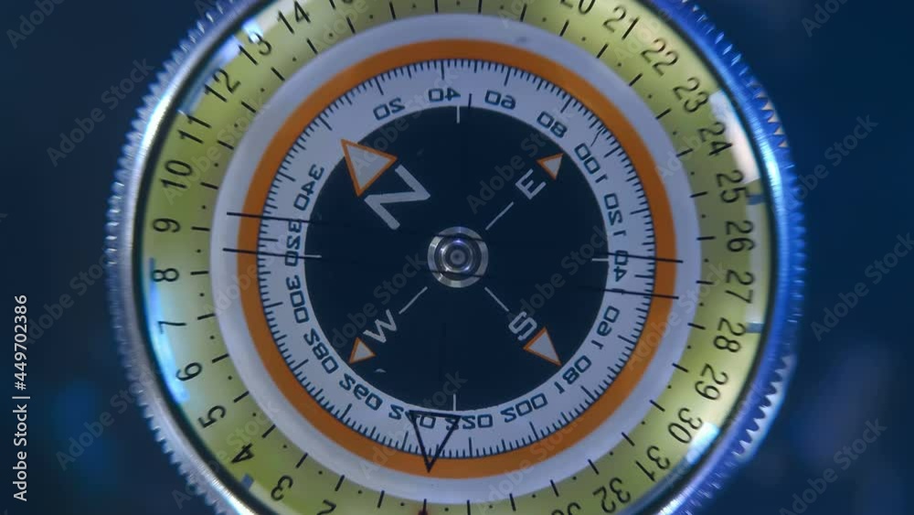 Compass with a rotating arrow on a black background, as a device for orientation on the ground and a symbol of travel around the world and geographic discoveries. Closeup
