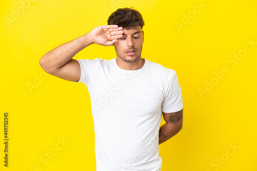 Young caucasian handsome man isolated on yellow background with tired and sick expression