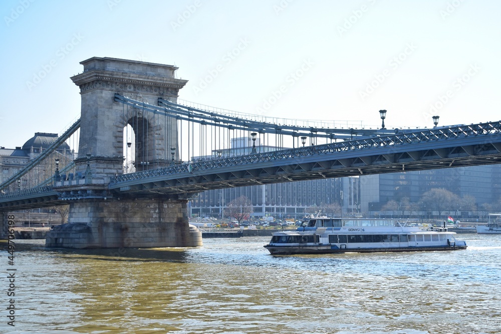 The Széchenyi Chain Bridge is a suspension bridge that spans the River Danube between Buda and Pest, the western and eastern sides of Budapest.