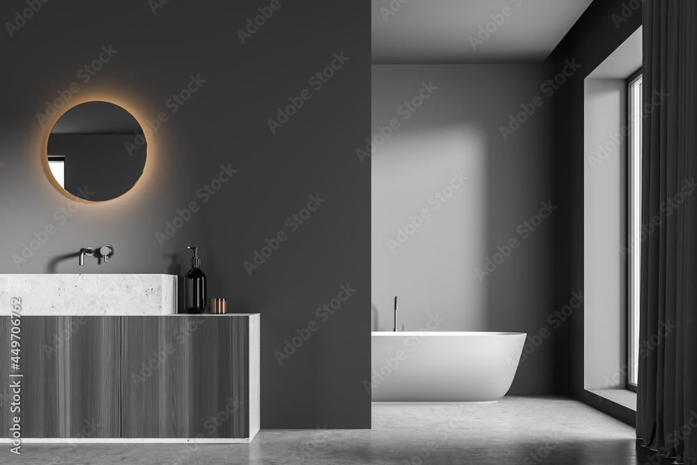 Dark grey bathroom with LED illuminated mirror on partition wall and ...