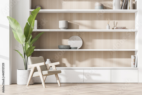 White wood niche shelf and armchair with indoor plant in seating area