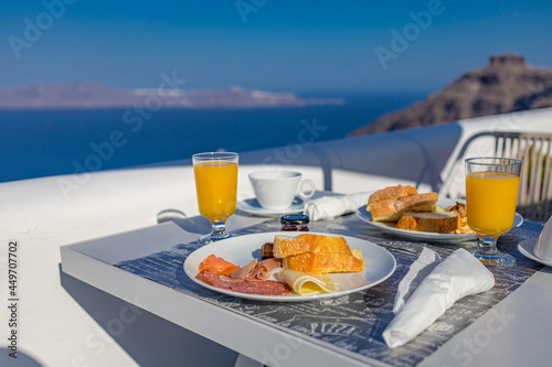 Morning fresh juice and breakfast with blue sea view. Couple traveling and honeymoon destination, idyllic morning scenic, bright caldera view in Greece, Santorini island. Romantic landscape, happiness