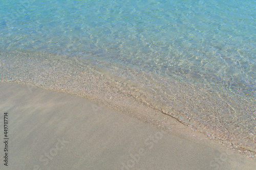 A small wave of the sea covers the sand on the paradise beach.