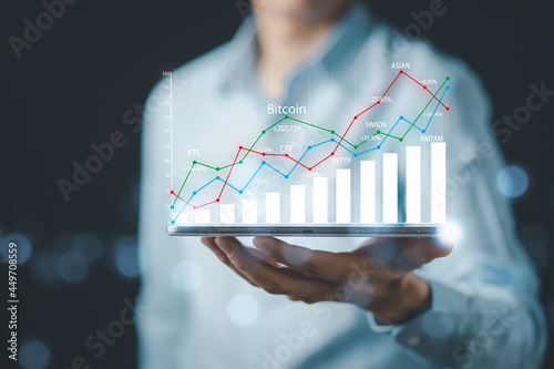 Businessman holding tablet bar graph of analytics and financial, Changes in new planning, Business growth, ideas and perspectives, Stock investment, and dividends yield from business in the new year.