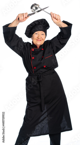portrait of an elderly cook. a woman in a cook's suit holds a knife and a scoop. A seasoned old sushi master, black uniform pastry chef is ready to go and very dangerous. determined. white, background