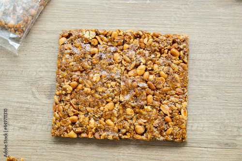 Asian sweet snacks, tasty mixed cut nuts, and caramel on wooden background natural light photo