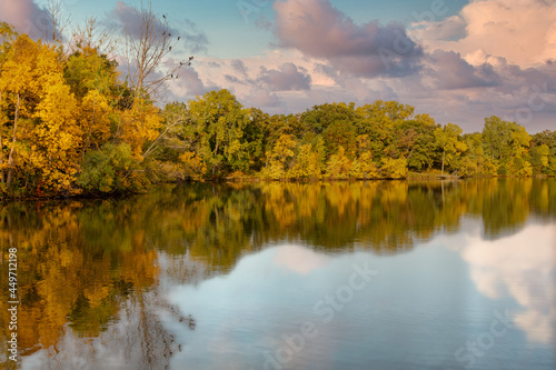 autumn colors. Trees reflecting in clear lake water. 