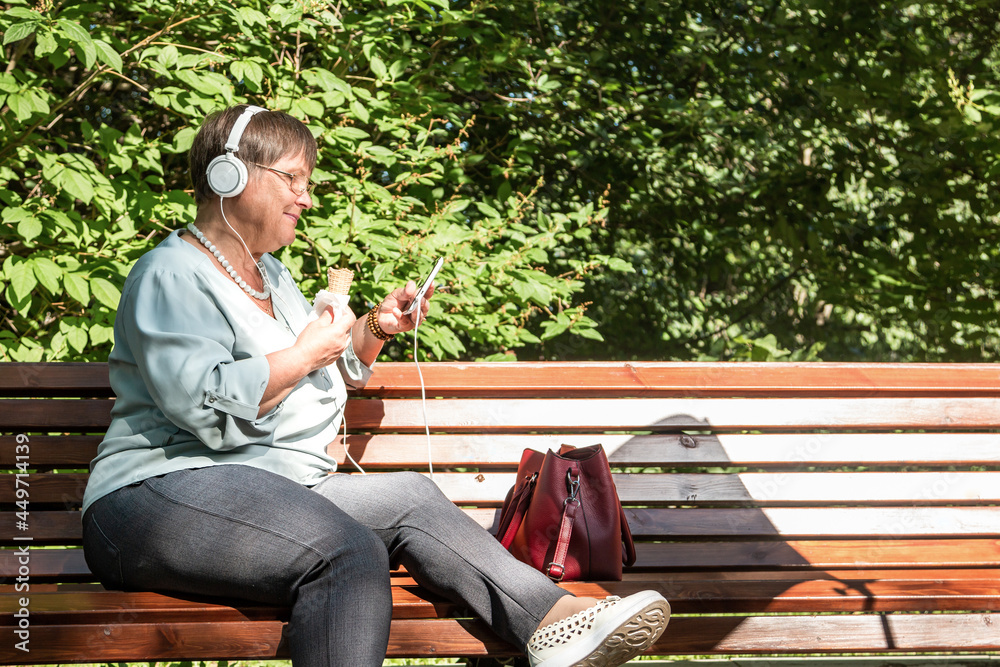 Grandma is eating ice cream in a summer park. Grandma is eating ice cream in a summer park.