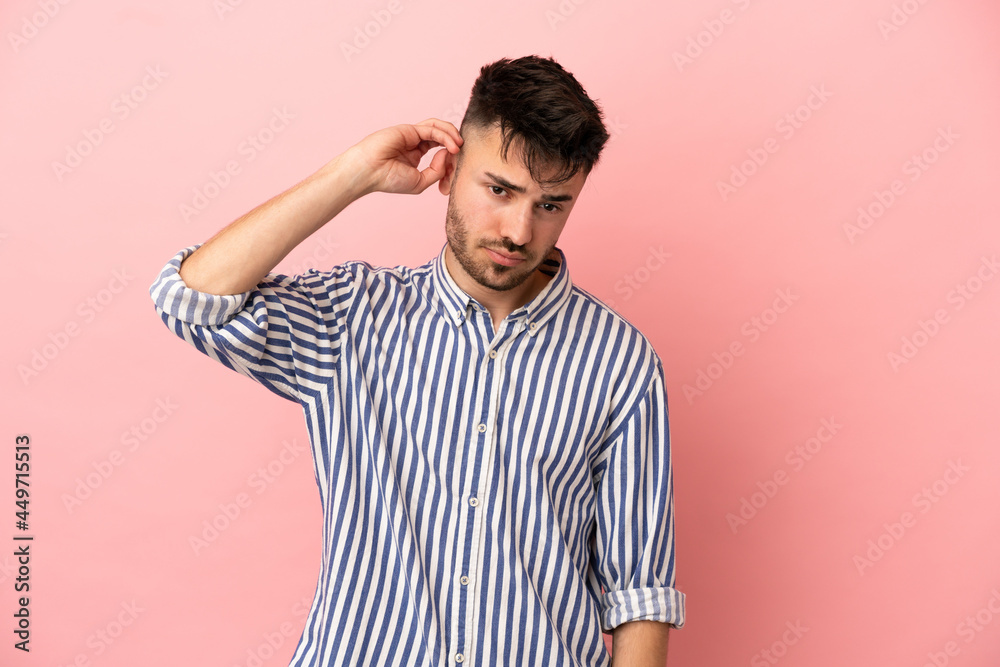 Young caucasian man isolated on pink background having doubts Young caucasian man isolated on pink background having doubts