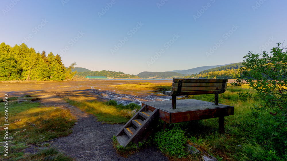 Raised viewing platform and bench overlooking mudflats during low tide for Burrard Inlet on Shoreline Trail at Port Moody - early summer morning during heatwave
