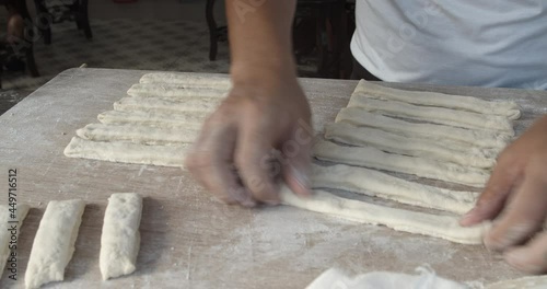 handheld 4K 25fps video of Chef is shaping dough sticks prepare to fry in hot oil.Youtiao is a hugely popular Chinese street food, a deep-fried breadstick crispy outside with a spongy interior. photo