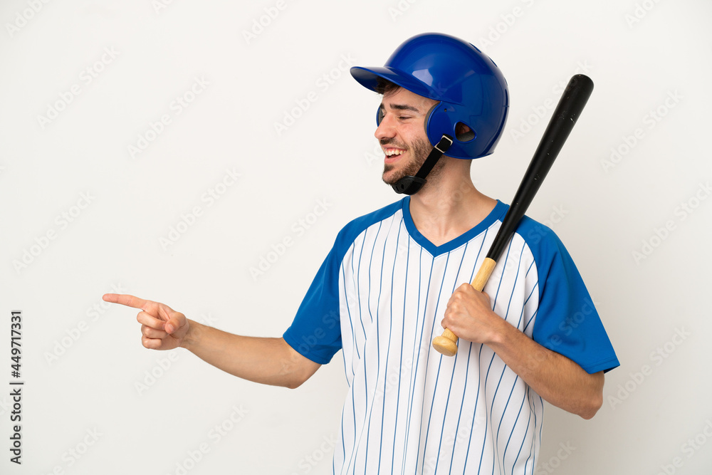 Young caucasian man playing baseball isolated on white background pointing finger to the side and presenting a product