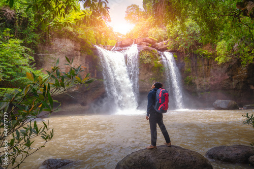 Tourists carry backpack, hiking nature trail, traveling ecotourism. Tourist trekking to see amazing beauty of Haew Suwat Waterfall. Unseen Khao Yai National Park, Thailand, UNESCO World Heritage Area. photo