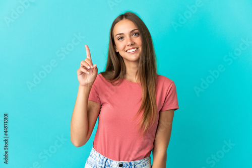 Young woman over isolated blue background pointing up a great idea