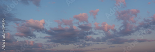 Pink, fluffy Cumulus clouds on a blue sky in the daytime