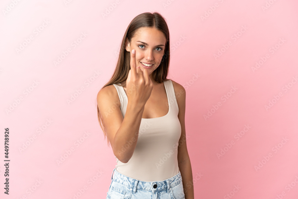 Young woman over isolated pink background doing coming gesture Young woman over isolated pink background doing coming gesture