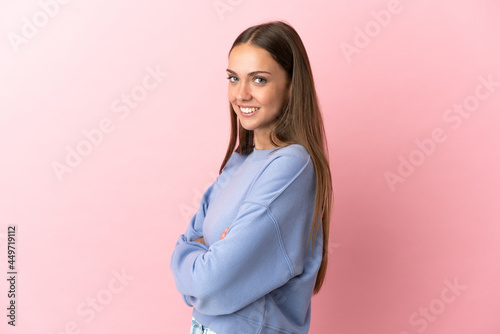 Young woman over isolated pink background with arms crossed and looking forward