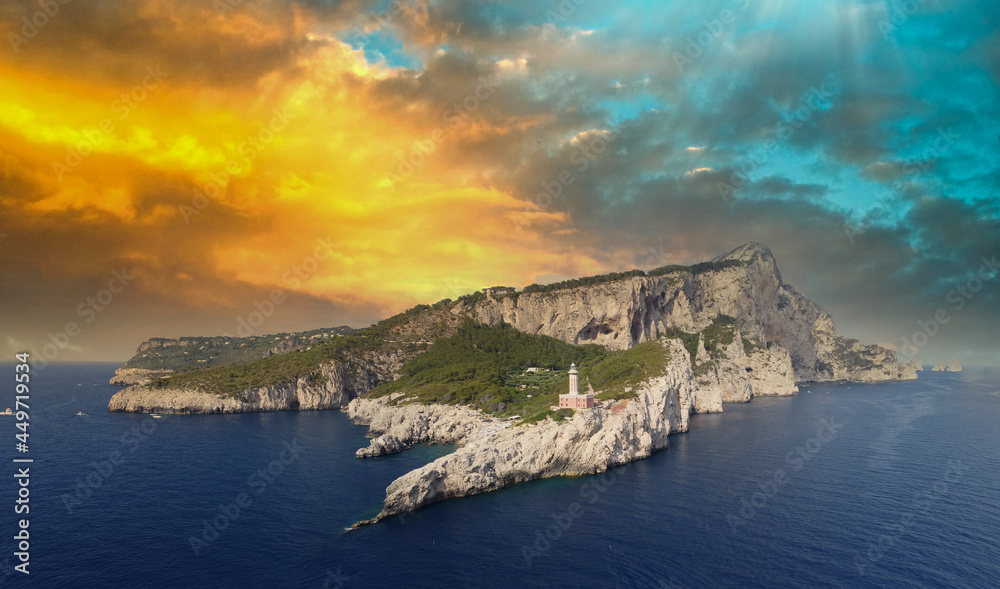 Amazing aerial view of Capri at sunset from a drone flying over lighthouse.
