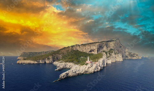 Amazing aerial view of Capri at sunset from a drone flying over lighthouse.