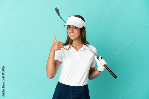Woman playing golf over isolated blue background with thumbs up because something good has happened
