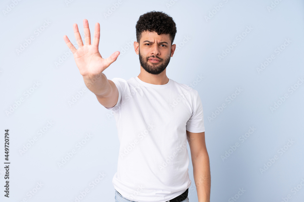 Young Moroccan man isolated on blue background counting five with fingers Young Moroccan man isolated on blue background counting five with fingers