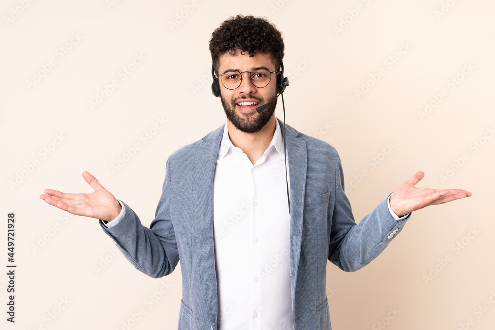Telemarketer Moroccan man working with a headset isolated on beige background with shocked facial expression Telemarketer Moroccan man working with a headset isolated on beige background with shocked facial expression