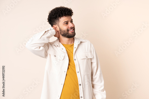 Young Moroccan man isolated on beige background thinking an idea © luismolinero