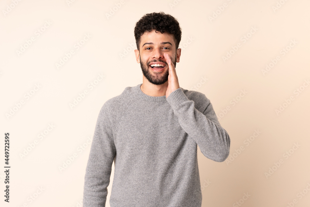 Young Moroccan man isolated on beige background with surprise and shocked facial expression Young Moroccan man isolated on beige background with surprise and shocked facial expression