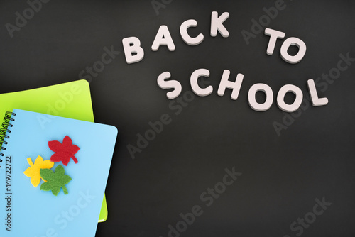 School supplies on a black school board. View from above. Place for your text. Back to school..