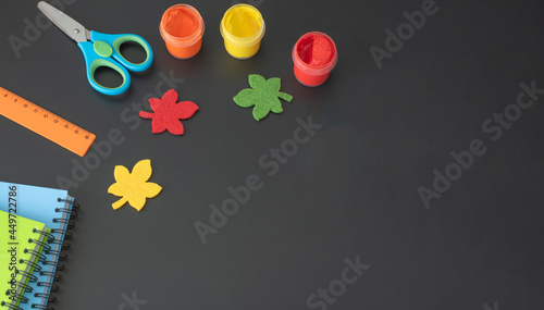 Art supplies and school supplies on a black school board. View from above. Place for your text.