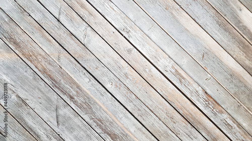 Gray wooden background with diagonal lines. Board background with copy space. Wooden old boards with cracked gray paint on the diagonal. Selective focus. Textured wooden background. Gray wooden background with diagonal lines. Board background with copy space. Wooden old boards with cracked gray paint on the diagonal. Selective focus. Textured wooden background.