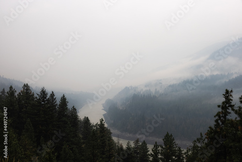 Trees on the side of a mountain in a valley covered by smoke from Forest Wildfire. Nature Disaster. Lytton, British Columbia, Canada. © edb3_16