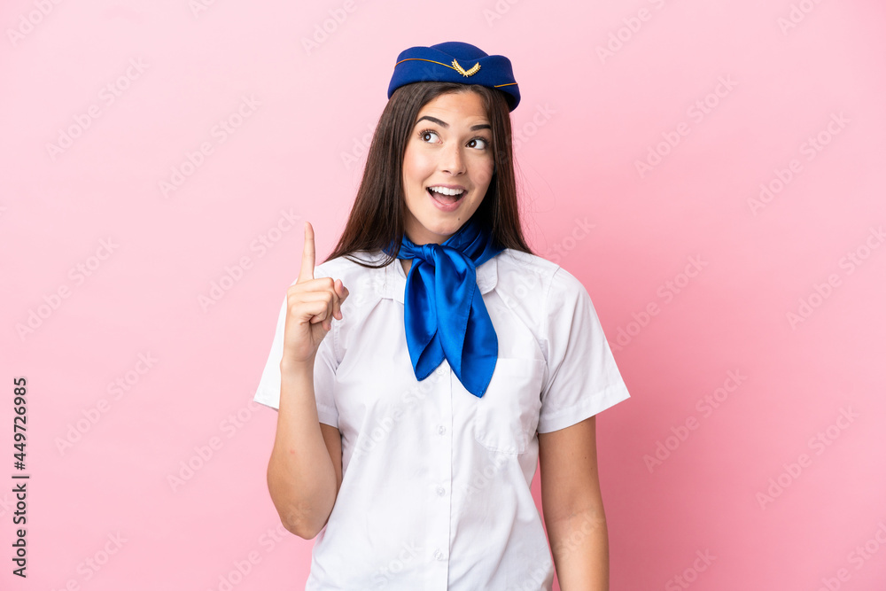 Airplane stewardess Brazilian woman isolated on pink background thinking an idea pointing the finger up
