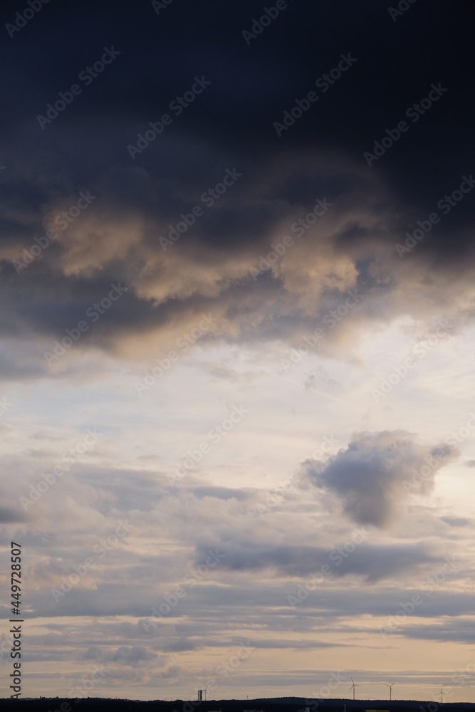 Dunkle Wolken am Himmel damatische Stimmung abends Unwetter mit Horizont Sillhouette Hochformat