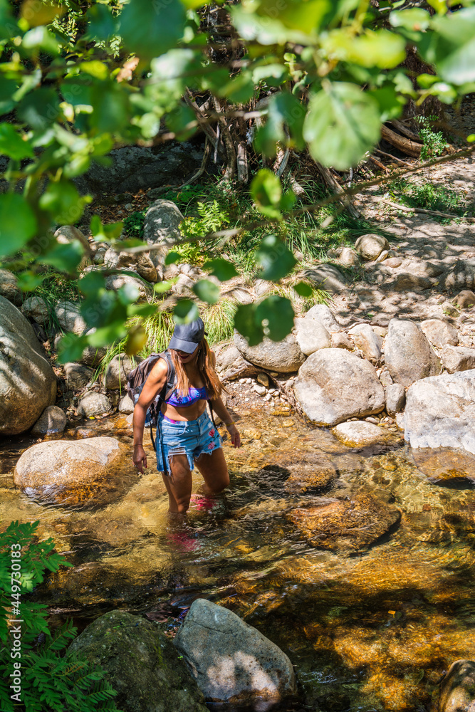 Woman enjoying an excursion in a forest she is walking along a river. Young Woman In Contact With Nature. Hiking in the north of Cáceres, Spain