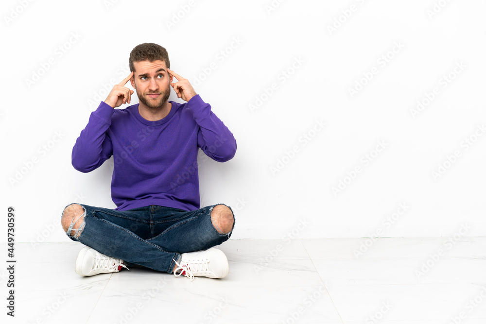 Young man sitting on the floor having doubts and thinking