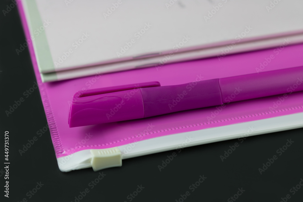 A pink folder a pen and a stack of notebooks Stock Photo | Adobe Stock