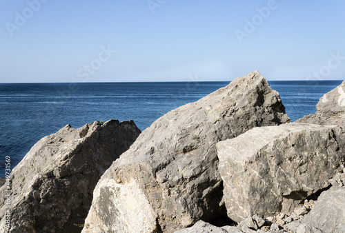 huge mountain boulders on the beach on a sunny day © Ольга
