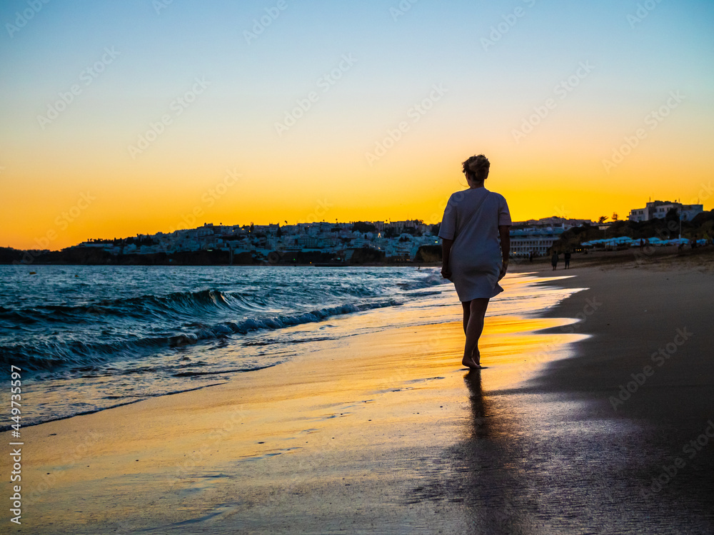 Middle-aged woman walking on beach
