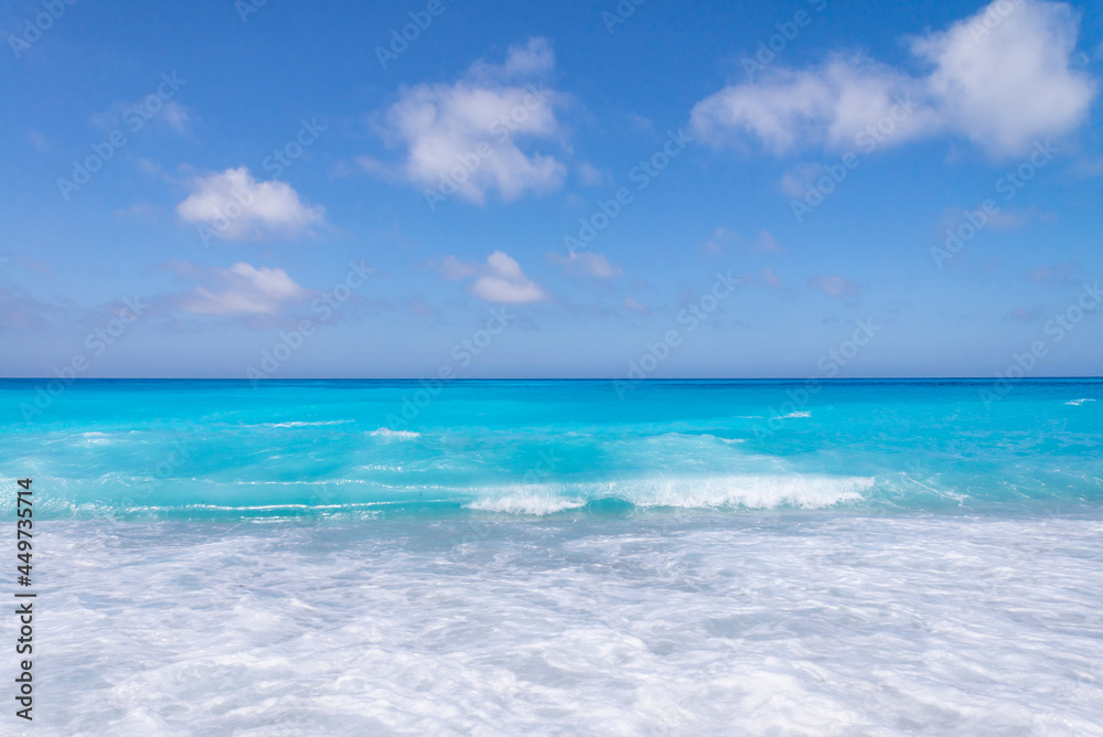 Tropical sand beach and blue sky, hot summer day, waves on the beach