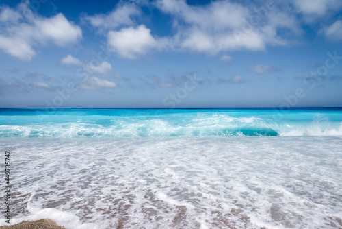 Tropical sand beach and blue sky, hot summer day, waves on the beach